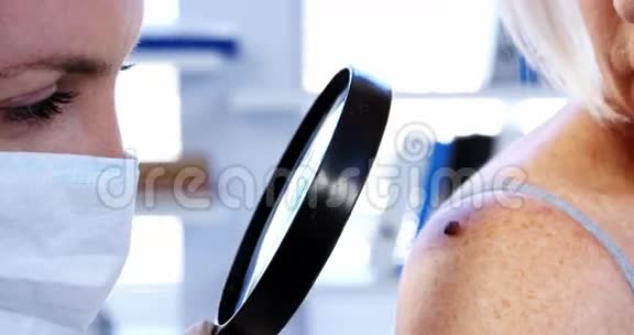 皮肤科医生用放大镜检查痣视频的预览图