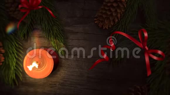 动画特写圣诞快乐文字蜡烛和绿色树枝在木头背景上视频的预览图