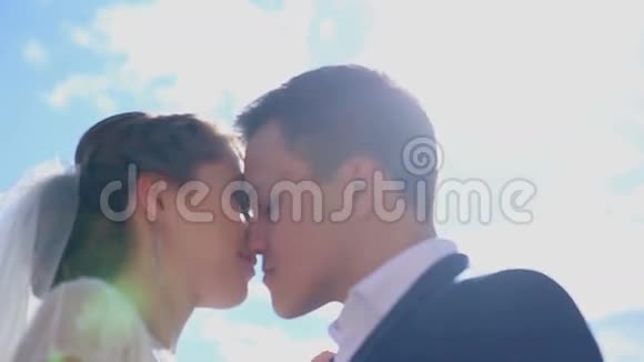 美丽的恋爱中的年轻夫妇刚刚结婚在阳光下接吻视频的预览图