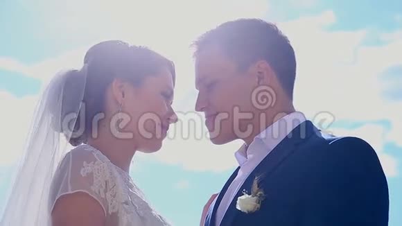美丽的恋爱中的年轻夫妇刚刚结婚在阳光下接吻视频的预览图