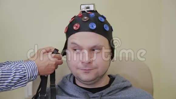医生给一个人戴上耳机来研究人脑视频的预览图