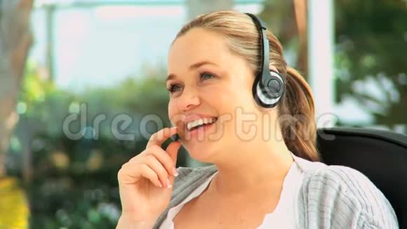 戴着耳机说话的漂亮女人视频的预览图