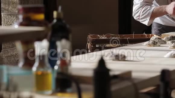 一家豪华鱼餐厅的厨师在桌上打开牡蛎把它们放在一个加冰的盘子里视频的预览图