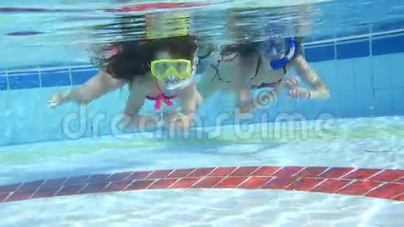 母亲和女儿在游泳池的水下游泳视频的预览图