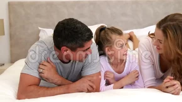 父母和女儿躺在床上聊天视频的预览图