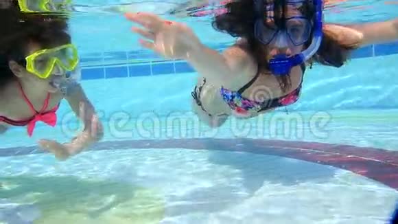 母亲和女儿在游泳池的水下游泳视频的预览图