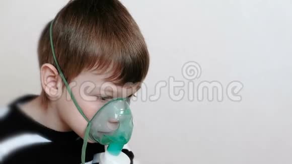 使用雾化器和吸入器进行治疗男孩通过吸入器面罩吸入侧视视频的预览图