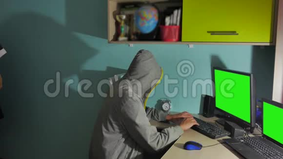在电脑上工作的男性黑客一个黑客把他的脸藏在室内视频的预览图