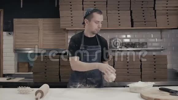 面包师用擀面杖把面团摊开年轻厨师做披萨送外卖视频的预览图