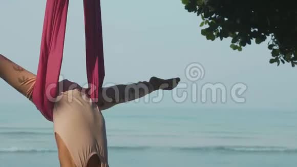 小可爱的女孩做瑜伽在海滩上吊床视频的预览图