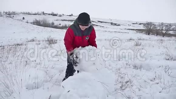少年滚雪球筑堡垒堆雪人冬天视频的预览图