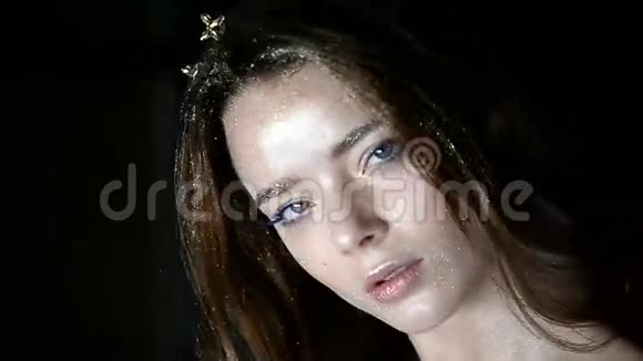 一个华丽的女孩的肖像头上装饰着皇冠的形状长长的头发在工作室里视频的预览图