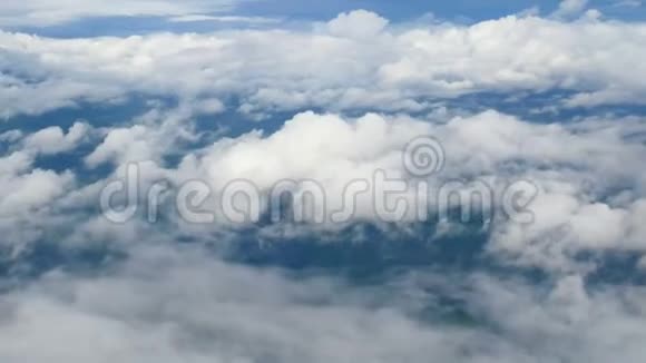 4K透过飞机窗户的鸟瞰蓝天背景下美丽的白云乘飞机旅行视频的预览图