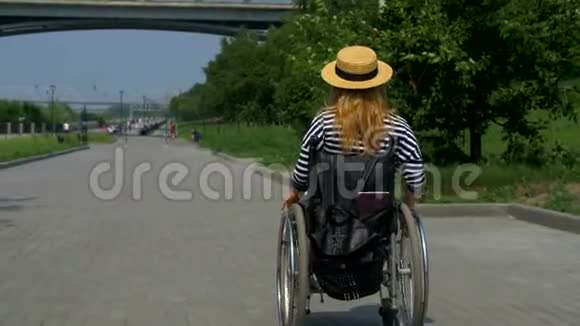 那个残废的女人坐在海滨的轮椅上视频的预览图
