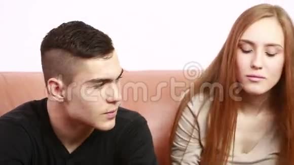 漂亮的年轻夫妇坐在沙发上争论不开心青年男女视频的预览图