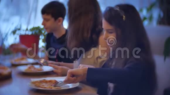 一家群孩子在咖啡馆里吃披萨近景儿童在室内青少年在咖啡馆吃快餐慢动作视频的预览图