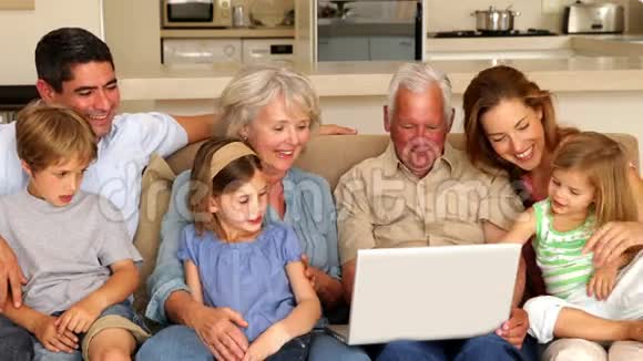 大家庭在沙发上一起使用笔记本电脑视频的预览图