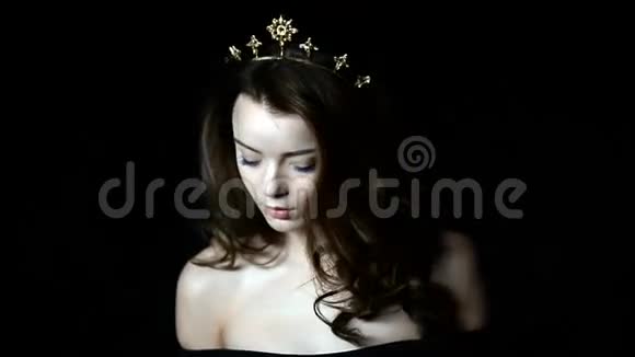 一个华丽的女孩的肖像头上装饰着皇冠的形状长长的头发在工作室里视频的预览图