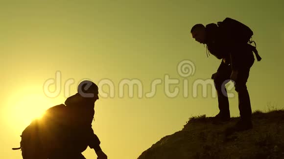 商务人员的团队合作登山者的身影互相伸展双手爬到山顶视频的预览图
