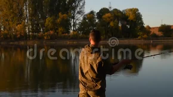 一个渔夫正在船上钓鱼一个年轻人正在河上的木船里钓鱼视频的预览图