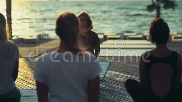 在海滩上练习瑜伽的女性团体视频的预览图