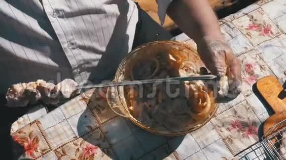 胖子把腌制的生肉放在一个绞架上以求在大自然上做一个ShishKebab视频的预览图