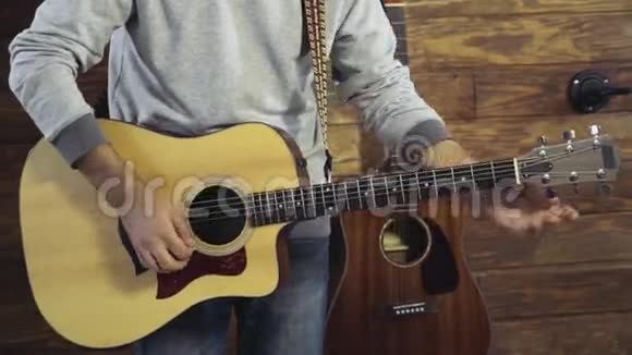 把男人的双手合拢调好一把吉他的慢动作视频的预览图