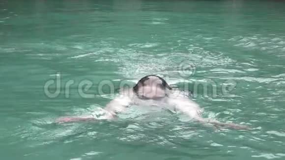 这位年轻的运动员在镜头前的一次蛙泳中漂浮在游泳池里视频的预览图