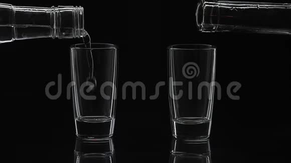 把两杯伏特加从瓶子里倒入玻璃杯里黑色背景视频的预览图
