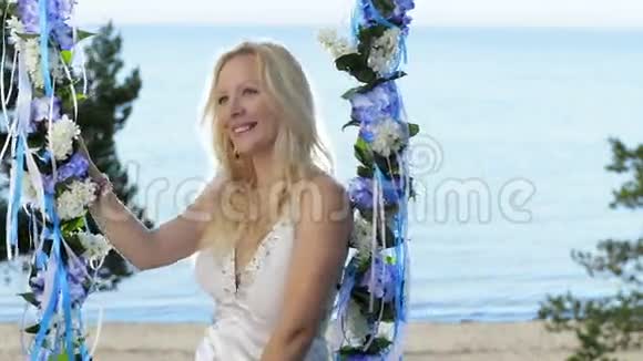 女士装饰的秋千和美丽的海边视频的预览图