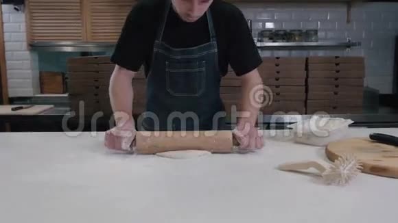 面包师用擀面杖把面团摊开年轻厨师做披萨送外卖视频的预览图