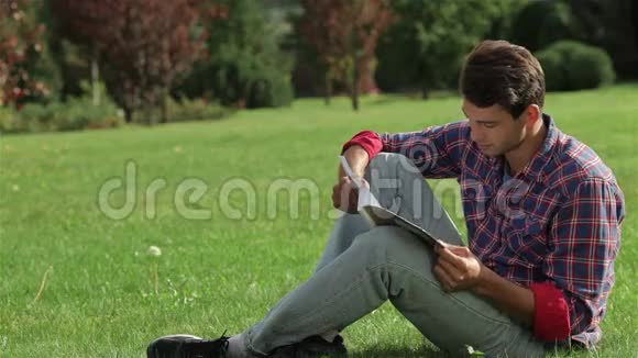 坐在草地上读书的人视频的预览图