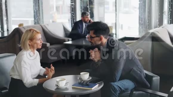 商业伙伴在午休时间讨论咖啡谈话中的合作视频的预览图