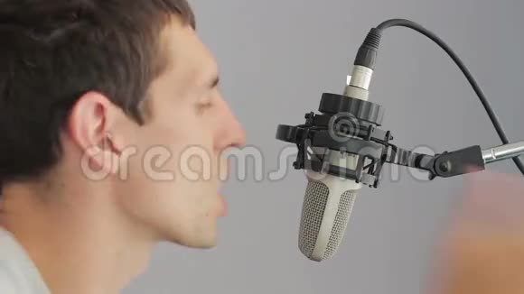 在录音室麦克风前唱歌的人视频的预览图