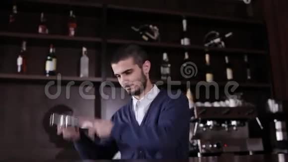 带摇床的酒保在现代酒吧做鸡尾酒英俊的酒吧男摇饮料视频的预览图