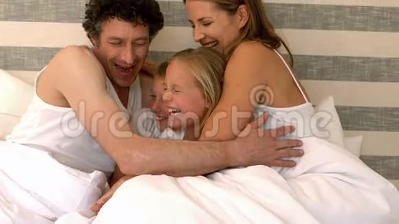 可爱的一家人在床上拥抱视频的预览图