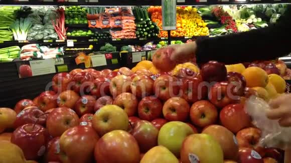 在杂货店挑选新鲜红苹果的女人视频的预览图
