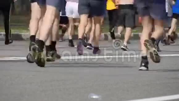 城市马拉松双脚的人城市街道上跑步的腿马拉松赛跑运动员的脚群视频的预览图