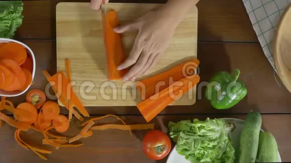 女主厨在厨房里做沙拉健康食品和切胡萝卜视频的预览图
