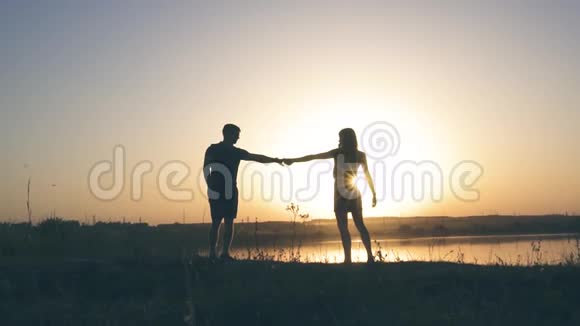 夏天在河流和日落的背景下年轻的一对迷恋在大自然中的夫妇视频的预览图