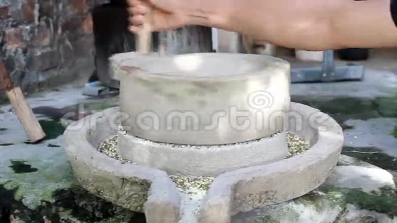 女人用磨石磨绿豆视频的预览图