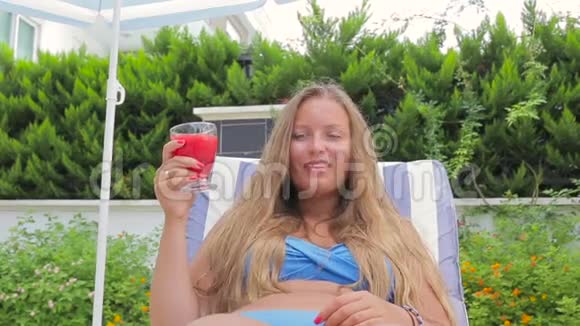 坐在池边喝果汁的美女视频的预览图