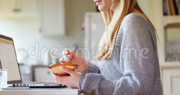 女性早餐时使用笔记本电脑4k视频的预览图