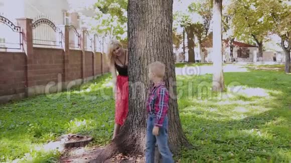 幸福快乐的家庭在公园的树旁拥抱和微笑视频的预览图
