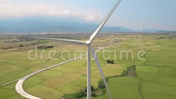 风车涡轮对绿色农业田和山地景观风轮在电站上的钻孔观察视频的预览图