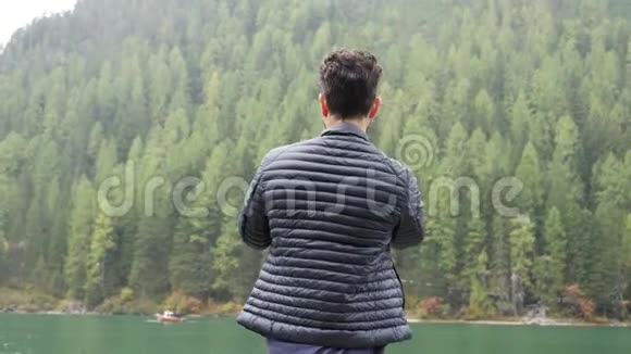 男子用智能手机在湖边拍照视频的预览图