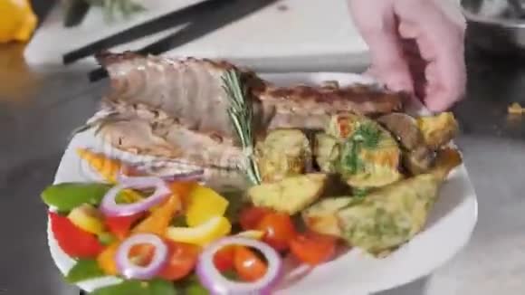 厨师在餐馆里准备烤羊排配炸土豆和新鲜蔬菜视频的预览图