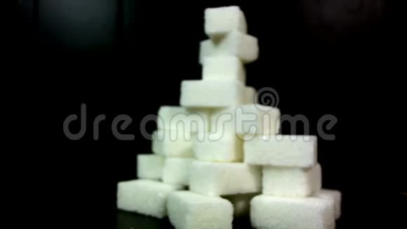 糖被灌在一堆糖块上在黑色背景下视频的预览图