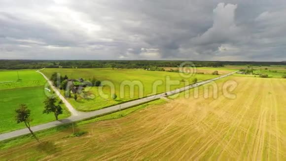 空中镜头飞过绿草如茵的田野美丽的巨大云层视频的预览图