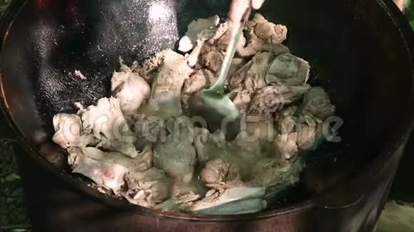 做皮拉夫菜在室外大锅里用切碎的羊肉烤蔬菜炖菜野营概念视频的预览图